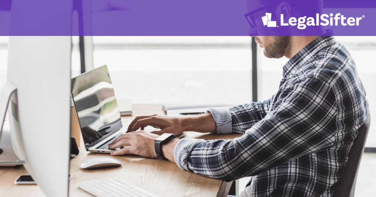 side view of businessman learning about AI contract review on desktop computer