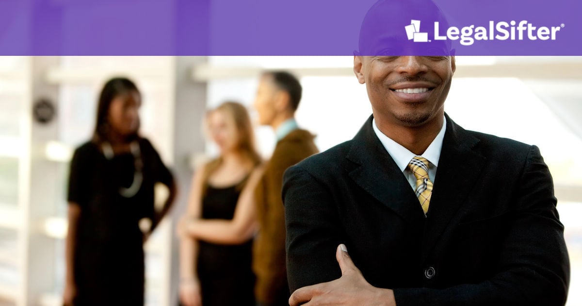 happy businessman stands with team in background after finding the best healthcare contract management software