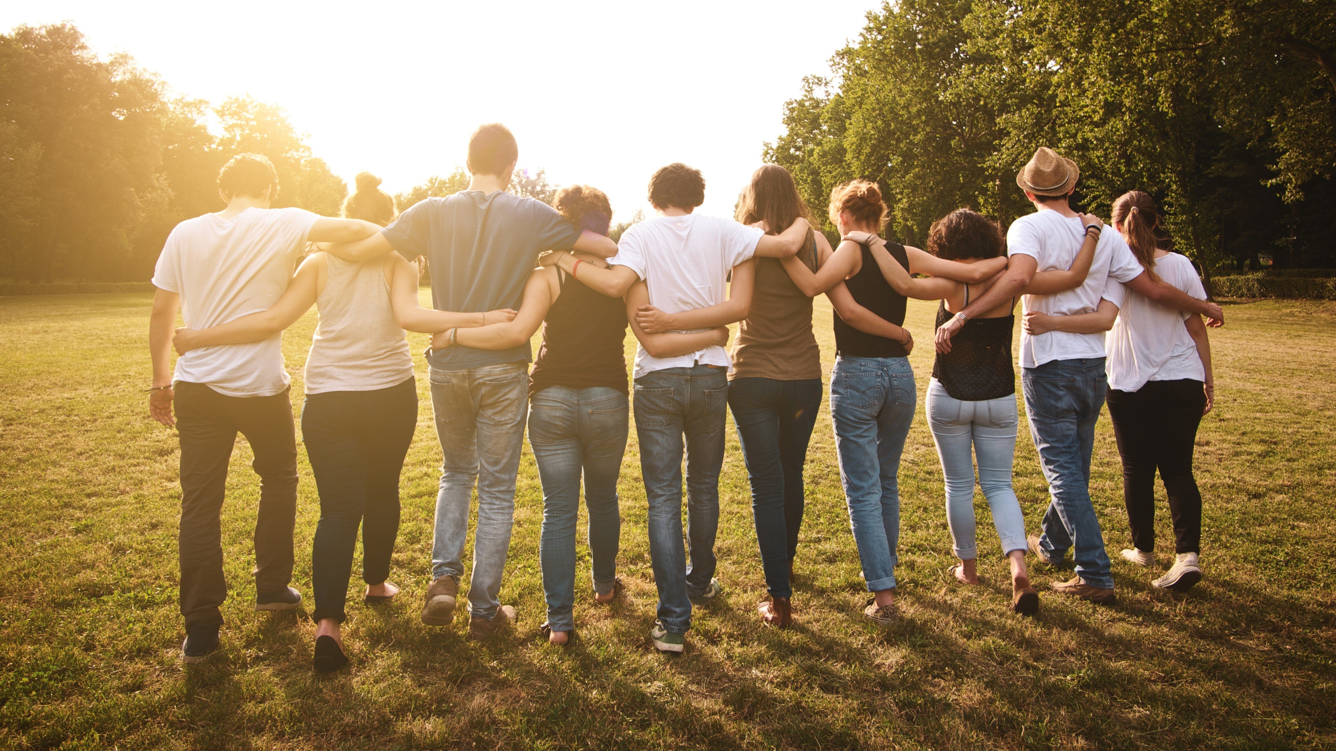 Nonprofit team members walking together outdoors with arms around each other, representing collaboration and mission-driven growth.
